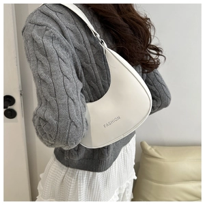 Chic white crescent shoulder bag featuring FASHION text detail on matte leather surface