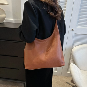 Brown leather crescent tote bag for women showing large capacity for daily use