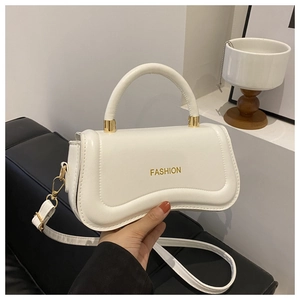 Détail du sac à main en cuir blanc avec texte FASHION doré et base incurvée élégante