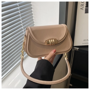 Close-up of beige leather bag featuring golden three-ring buckle and elegant metal chain