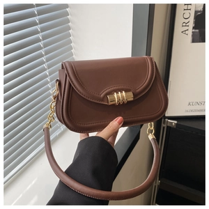 Detailed view of dark brown leather crossbody bag with cylindrical gold metal lock buckle