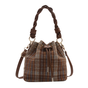 Minimalist brown and blue plaid bucket bag with braided leather handle and drawstring