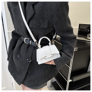 Close-up of a white lychee leather crossbody bag with gold hardware and top handle