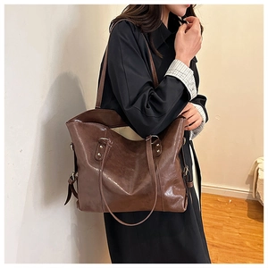 Detailed view of the dark brown retro leather tote bag worn by a model for daily use