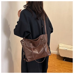 Detail of deep brown leather tote bag showing large capacity and stylish wide shoulder strap