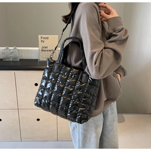Détail du grand sac cabas noir matelassé en nylon brillant avec bandoulière fine