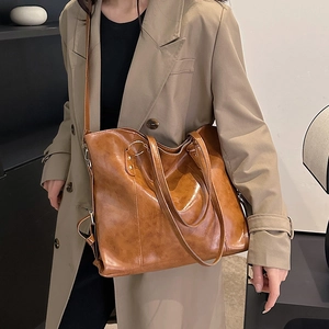 Classic brown leather tote bag with long shoulder straps for women in casual fashion look