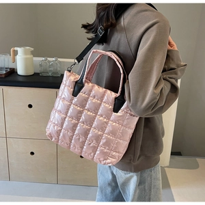 Détail du cabas rose matelassé montrant le tissu en nylon brillant et la texture de losange