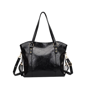 Minimalist black oil wax leather tote bag with gold hardware and adjustable strap