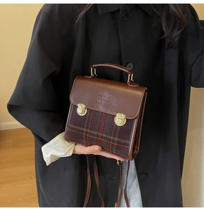 Detail view of brown leather and plaid fabric texture with gold metallic buckle closures