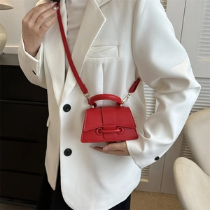 Red mini leather crossbody bag for women featuring a top handle and textured finish