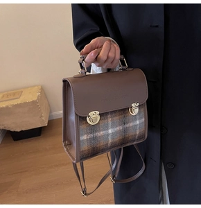 Detail of vintage brown plaid handbag with golden double locks and embossed logo