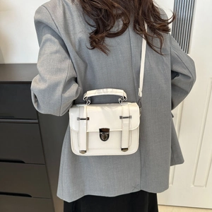 Détail du petit sac blanc vintage avec bandoulière réglable et fermoir métallique rétro