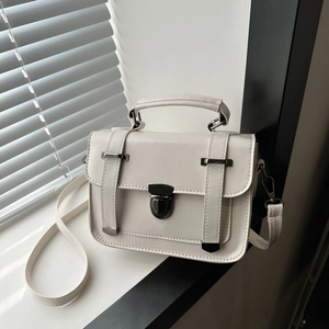 Détail du petit sac à bandoulière vintage crème avec serrure en métal et fine sangle