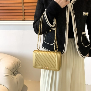 Golden quilted metallic leather crossbody bag with chain strap and rectangular turn-lock