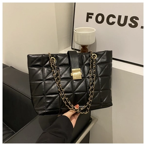 Détail du sac cabas matelassé noir avec bandoulière chaîne dorée et fermoir carré