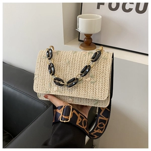 Détail du sac bandoulière en paille beige avec broderie florale et sangle jacquard chic