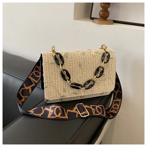 Détail du sac bandoulière en paille beige avec broderie florale et deux sangles