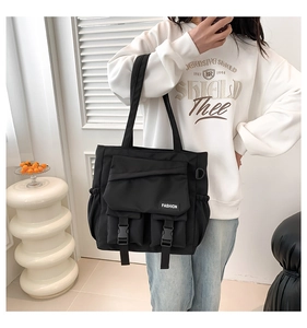 Détail du sac fourre-tout noir fonctionnel avec poches à boucle tactique et étiquette mode