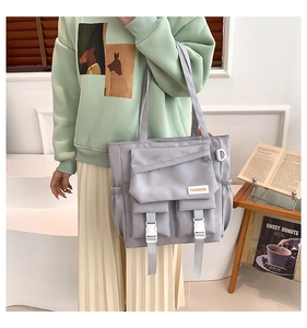 Détail du sac fourre-tout en nylon lilas avec design multi-poches et boucles blanches