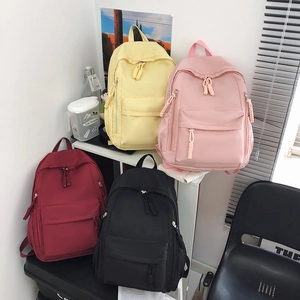 Minimalist nylon backpacks in four colors with woven zipper pulls and multiple pockets