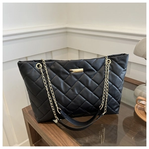 Detail der schwarzen gesteppten Shopper-Tasche mit goldener Kette und Beschlägen