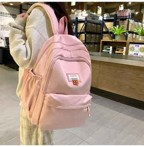 Pink waterproof nylon backpack detail with cushioned straps and side storage pockets