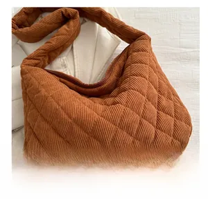 Gros plan du sac en velours côtelé marron avec motif matelassé et fermeture à glissière