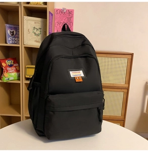 Close-up of black waterproof nylon backpack featuring fashion label and side pocket