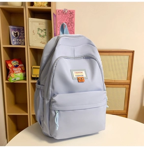 Detailed view of casual backpack with orange smiley face patch and fashion label