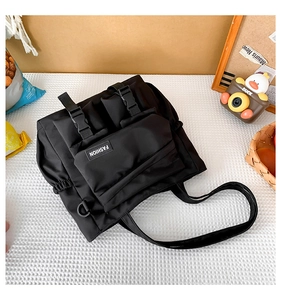 Détail du sac fourre-tout noir en nylon avec poches à boucle et étiquette de mode