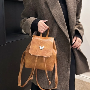 Vintage caramel brown faux leather backpack with silver butterfly accent and drawstring