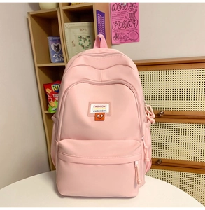 Close-up of pink nylon backpack featuring fashion embroidery and functional zipper pocket