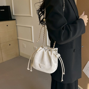 Elegant white drawstring bucket bag with gold chain strap and metal ball accessory