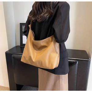 Close-up of a large camel hobo bag featuring lychee texture and knotted strap details
