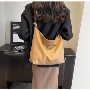 Close-up of brown lychee texture tote bag featuring unique knot detail on shoulder strap