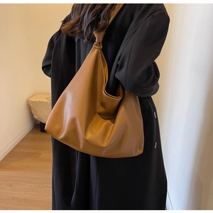 Close-up of caramel hobo bag featuring lychee texture leather and unique knot strap detail