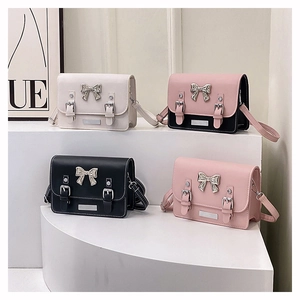 Detailed view of four colorful mini crossbody bags with metallic silver bow accents