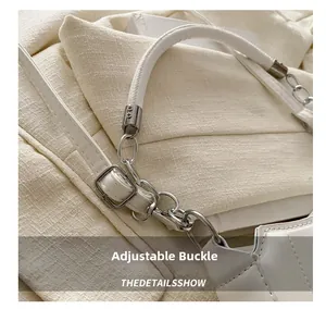 Detail showing the adjustable white leather shoulder strap with a silver metal buckle