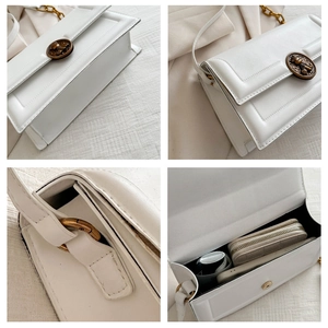 Detail view of white PU leather flap bag with antique bronze bear buckle and chain strap