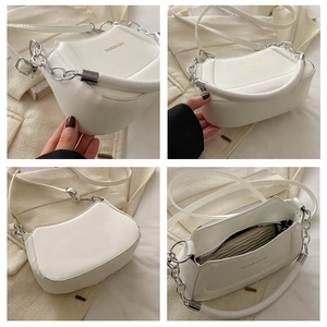 Detail view of white ruched shoulder bag with silver chain strap and internal pocket