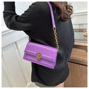 Detail view of purple leather crossbody bag with vintage gold chain strap and metal clasp