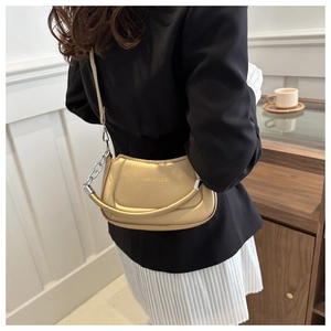 Champagne gold vintage shoulder bag featuring silver chain detail and sleek leather texture