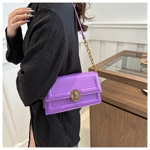 Close-up of a purple crossbody bag featuring a golden vintage buckle and fine leather texture