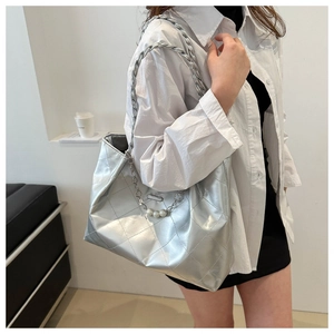 Detail of silver quilted tote with woven chain strap and decorative pearl pendants
