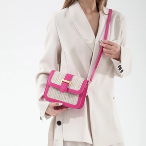 Chic straw and pink leather crossbody square bag with gold buckle shown on model