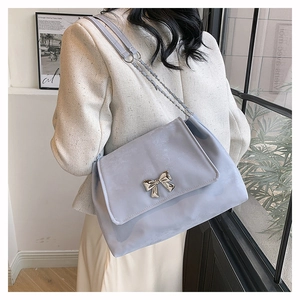 Light blue crossbody bag with silver butterfly buckle and leather chain strap detail