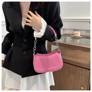Pink matte leather crescent bag with silver chain strap shown worn by a model