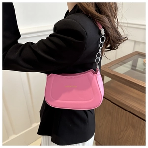 Detail view of pink PU leather dumpling bag with silver chain and gold logo text