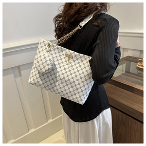 Detail of white monogram tote bag with gold chain strap and mini round coin purse charm